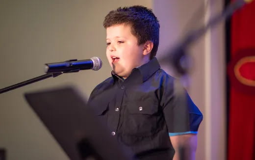 a boy standing at a podium