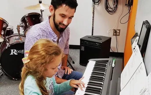 a person and a girl playing a piano