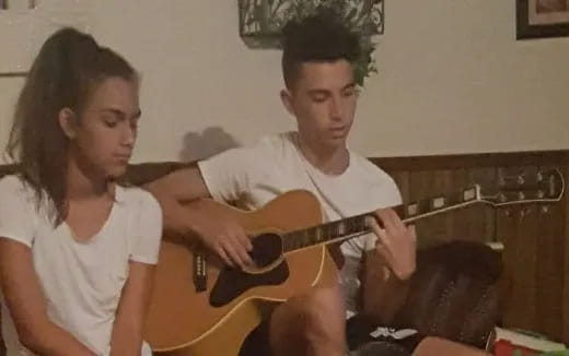a man and a woman playing a guitar