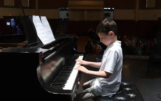 a boy playing a piano