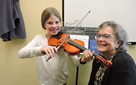 a person playing a violin next to a person