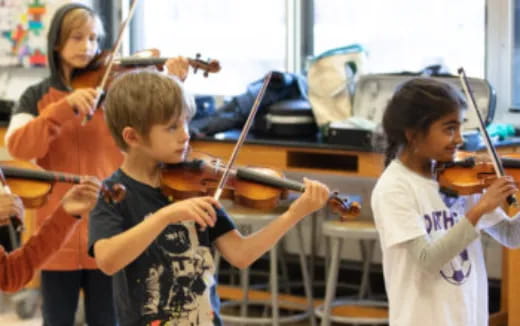 a group of kids playing violin