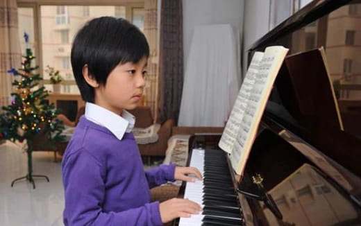 a young boy playing a piano