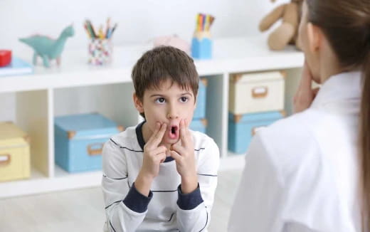 a boy with his hands on his face