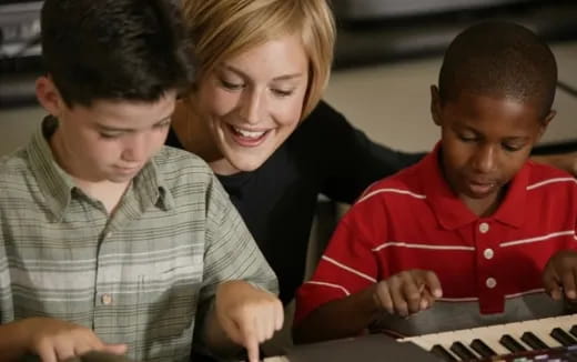 a person and several children looking at a computer