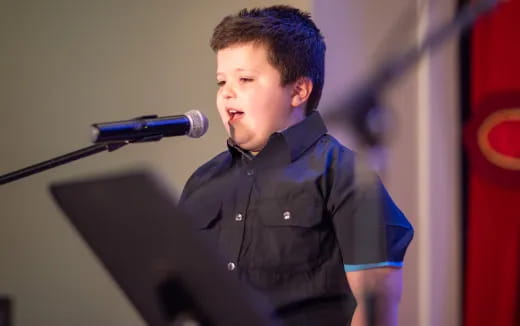 a boy standing at a microphone