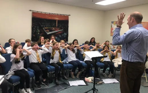 a person standing in front of a group of students in a classroom