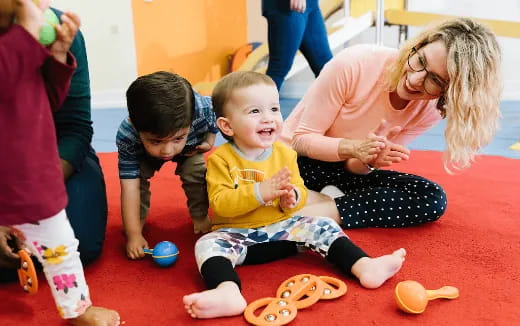 a person and two children sitting on the floor