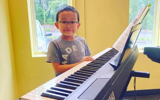 a boy sitting at a piano