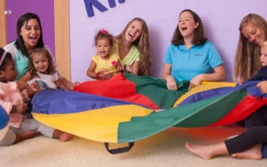 a group of women sitting on a colorful trampoline