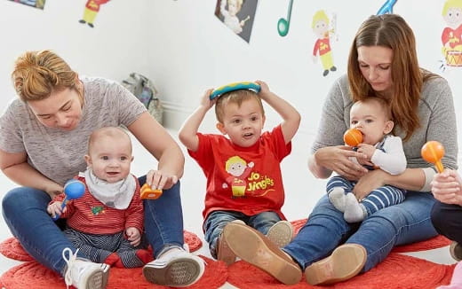 a group of people sitting on the floor with toys