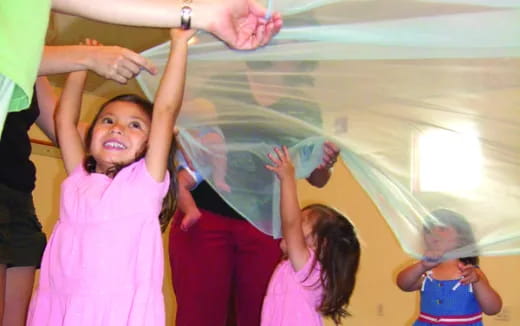 a group of children raising their hands