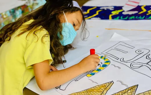 a girl drawing on a paper