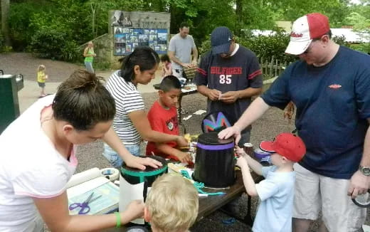 a group of people gathered around a table with pots and pans