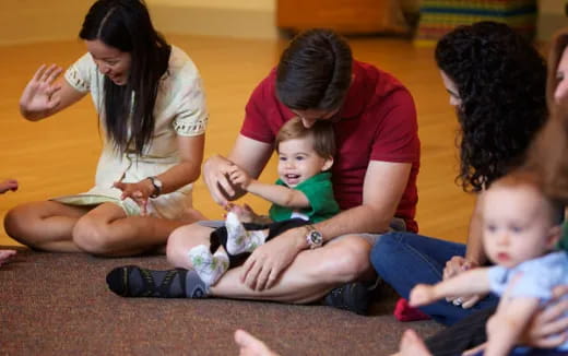 a group of people sitting on the floor with a baby
