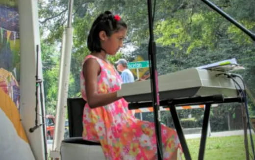 a person in a dress playing a piano