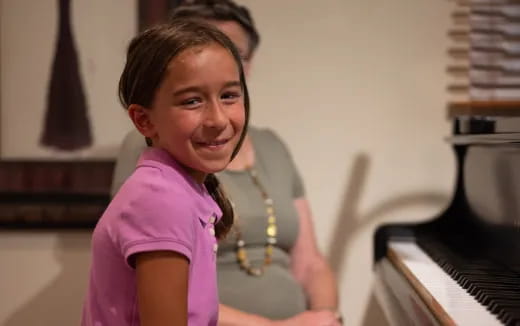 a girl smiling and holding a saxophone