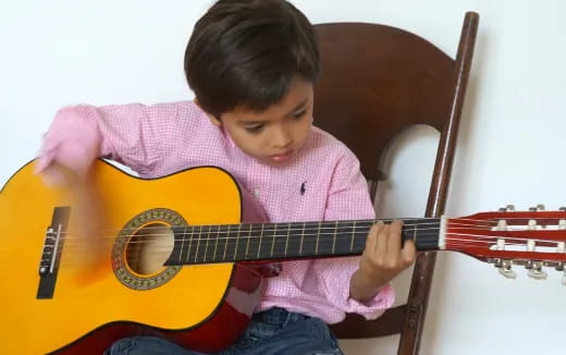 a young boy playing a guitar