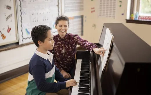 a person and a boy playing piano