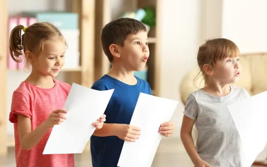 a group of children holding papers