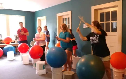 a group of people in a room with balloons