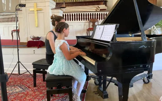 a couple of women playing piano