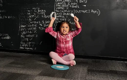 a child sitting on a chalkboard