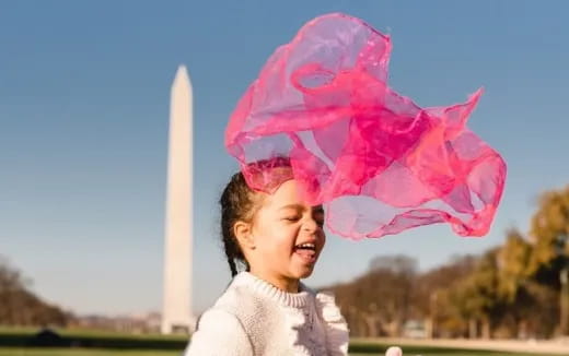 a child with a large pink and white explosion in the background