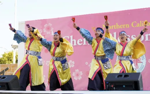 a group of women in traditional dress dancing on a stage