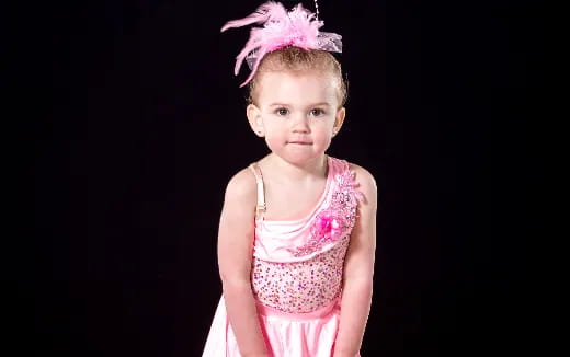 a little girl wearing a pink dress