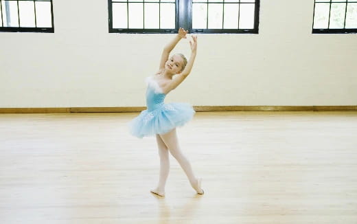 a girl wearing a blue dress and dancing on a stage