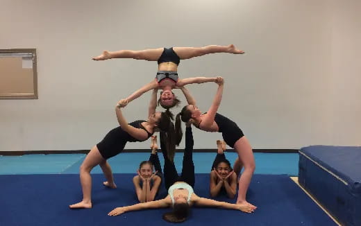 a group of people doing acrobats on a mat
