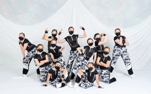 a group of people in black and white clothes posing for the camera