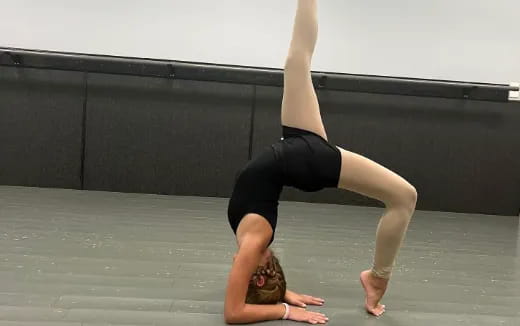 a woman doing a handstand on a mat