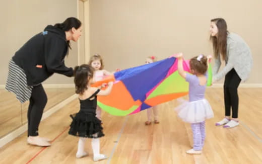 a person and a group of children holding a kite