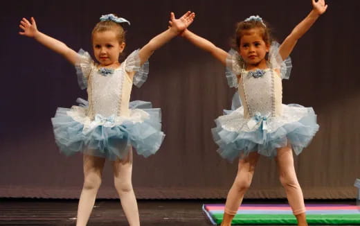 two girls wearing blue dresses and dancing