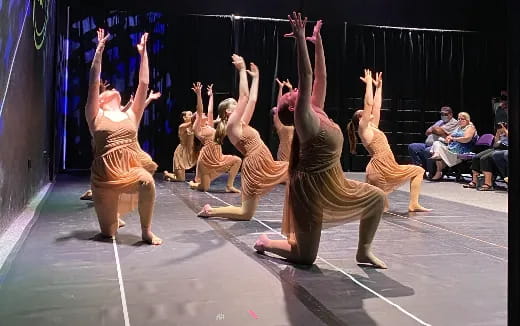 a group of dancers performing on stage