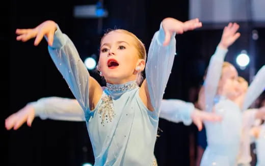 a young girl with her arms raised