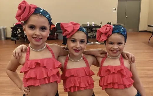 a group of girls wearing pink dresses