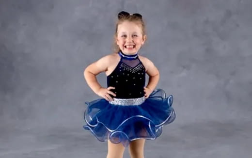 a girl wearing a blue dress and dancing