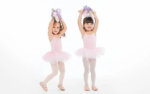 two girls wearing dresses and posing for a picture