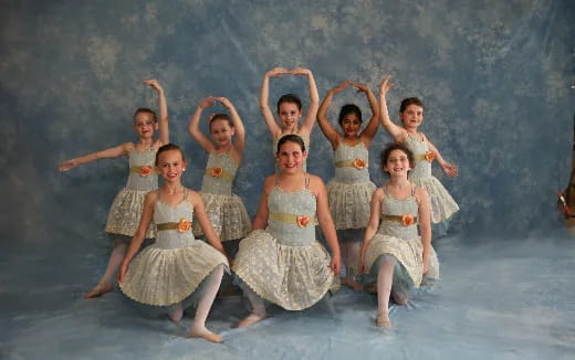 a group of children in dresses jumping in the air