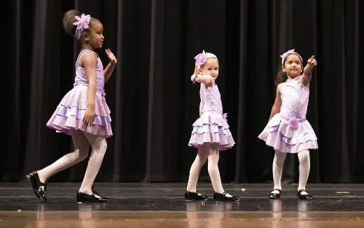 a group of girls in dresses dancing