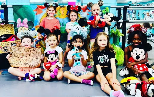 a group of children sitting on the floor with stuffed animals