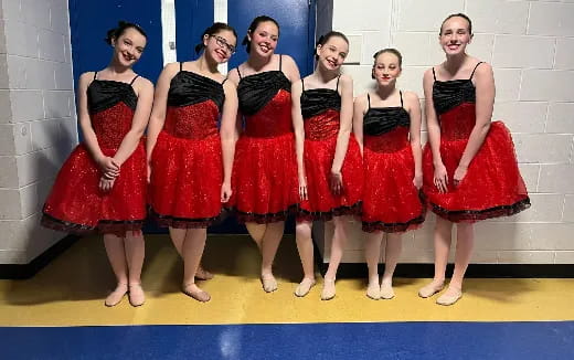 a group of women in red dresses