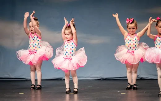 a group of girls in dresses dancing