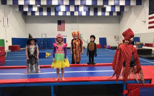 a group of children in clothing on a stage