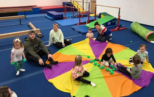 a group of people playing on a colorful mat