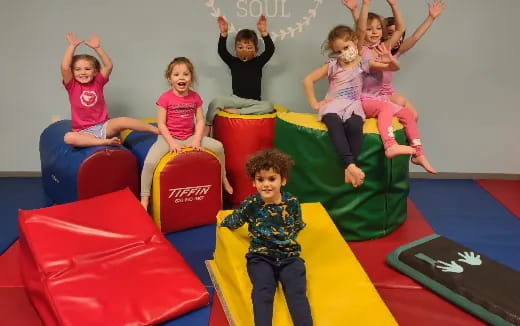 a group of children sitting on colorful chairs