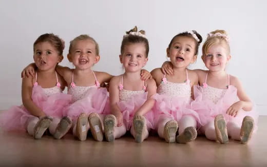 a group of children in pink dresses